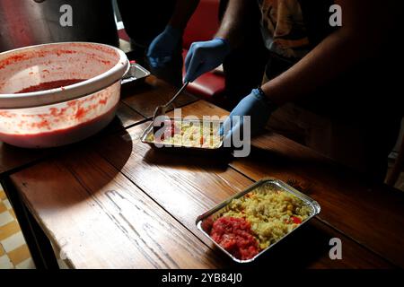 Beirut, Beirut, Libano. 17 ottobre 2024. I volontari libanesi preparano il cibo in un pub locale a Beirut. Il cibo è dedicato alle minoranze straniere intrappolate nell'escalation della guerra tra Israele e gli Hezbollah filo-iraniani. Tra gli esodi di massa di persone che cercano di fuggire da attacchi aerei israeliani mortali in Libano vi sono lavoratori domestici migranti provenienti da paesi come Kenya, Filippine, Etiopia e Sudan, alcuni dei quali si sentono intrappolati e incapaci di mettersi in sicurezza. (Credit Image: © Marwan Naamani/ZUMA Press Wire) SOLO PER USO EDITORIALE! Non per USO commerciale! Foto Stock