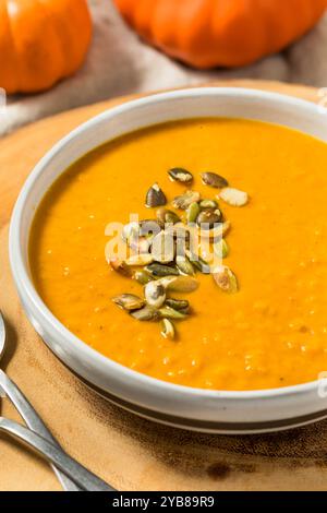 Zuppa di zucca autunnale fatta in casa con panna e semi in una ciotola Foto Stock