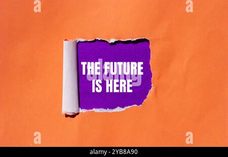 Il futuro è qui messaggio scritto su carta strappata arancione con sfondo viola. Concettuale il futuro è qui simbolo. Copia spazio. Foto Stock