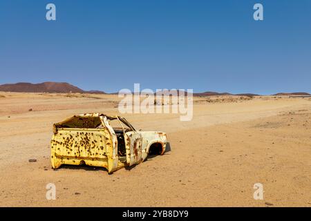 Vecchio relitto di auto gialle arrugginito nel deserto, paesaggio della Namibia, Africa Foto Stock