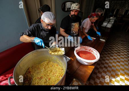 Beirut, Libano. 17 ottobre 2024. I volontari libanesi preparano il cibo in un pub locale a Beirut. Il cibo è dedicato alle minoranze straniere intrappolate nell'escalation della guerra tra Israele e gli Hezbollah filo-iraniani. Tra gli esodi di massa di persone che cercano di fuggire da attacchi aerei israeliani mortali in Libano vi sono lavoratori domestici migranti provenienti da paesi come Kenya, Filippine, Etiopia e Sudan, alcuni dei quali si sentono intrappolati e incapaci di mettersi in sicurezza. (Credit Image: © Marwan Naamani/ZUMA Press Wire) SOLO PER USO EDITORIALE! Non per USO commerciale! Foto Stock