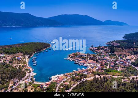 Veduta aerea di Fiskardo, Cefalonia. Pittoresco villaggio adagiato su una penisola, circondato da acque turchesi. Case colorate, piccola spiaggia e barca Foto Stock