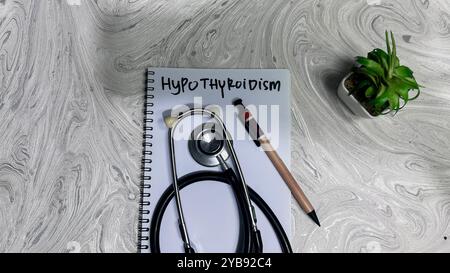 Concetto di ipotiroidismo scrivere su libro isolato su tavolo di legno. Foto Stock