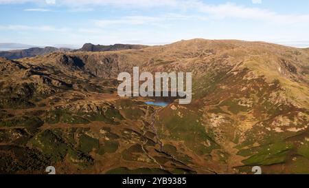 Vista aerea del lago di montagna noto come Easedale Tarn sopra il villaggio di Grasmere nel Lake District National Park che mostra la disposizione geografica di un Foto Stock