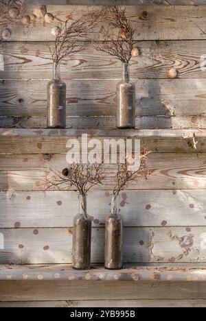 Fiori secchi decorativi in vasetti di od e bottiglie su sfondo di legno, utilizzati come decorazione da ristorante all'esterno di una taverna greca Foto Stock