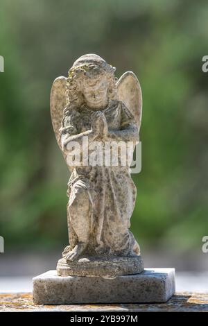 Scultura in pietra di angelo pregante in un cimitero sull'isola greca di Zante o Zante in Grecia Foto Stock