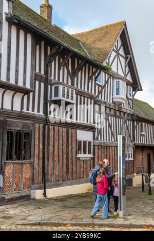 Famiglia di turisti che guarda la mappa informativa fuori dalla casa Tudor Museum and Gallery attrazione turistica casa storica in Bugle Street, Southampton Foto Stock