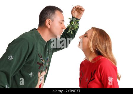 Coppia matura baciando sotto ramo mistletoe su sfondo bianco Foto Stock
