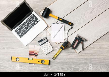 Attrezzi, laptop e schede laminate a pavimento Foto Stock