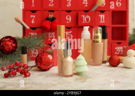 Diversi prodotti cosmetici, calendario dell'avvento e decorazioni natalizie sul tavolo Foto Stock