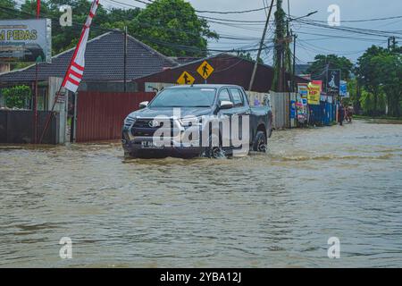 Balikpapan, Indonesia - 9 agosto 2024. La Toyota a doppia cabina 4wd nera sta guidando attraverso la forte corrente. Foto Stock