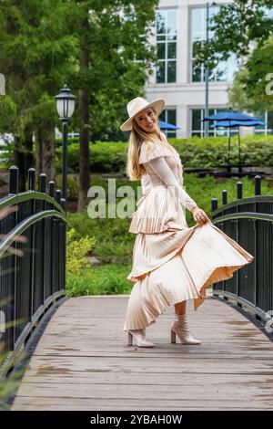 Uno splendido modello mostra la moda autunnale tra la bellezza della natura, trasuda eleganza e fascino in una pittoresca passeggiata nel parco Foto Stock