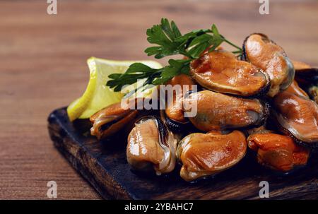 Cozze senza guscio, bollite, cozze, sbucciate, su un tagliere, con limone e prezzemolo, cozze in cileno, vista dall'alto, nessuna gente Foto Stock