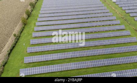 Vista aerea di più file di pannelli solari su un campo erboso Foto Stock