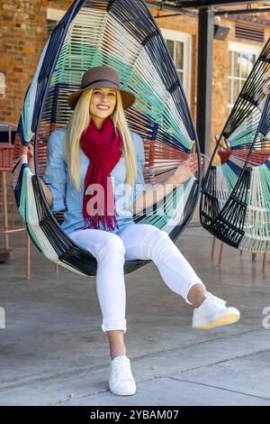 La bellezza bionda trasuda gioia con l'elegante abbigliamento autunnale, che irradia gli spiriti in una splendida giornata autunnale Foto Stock