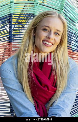 La bellezza bionda trasuda gioia con l'elegante abbigliamento autunnale, che irradia gli spiriti in una splendida giornata autunnale Foto Stock