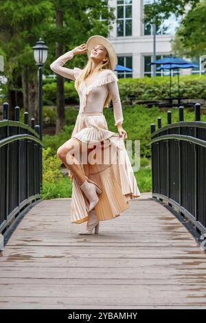 Uno splendido modello mostra la moda autunnale tra la bellezza della natura, trasuda eleganza e fascino in una pittoresca passeggiata nel parco Foto Stock