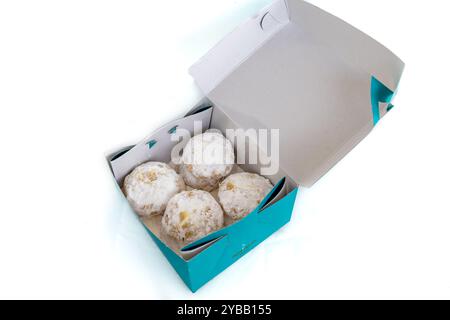 Una scatola di Kourabiedes, biscotti al burro greci della panetteria, isolati su sfondo bianco. Foto Stock