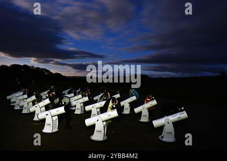 Un gruppo di stelle utilizza i telescopi per dare un'occhiata alla Cometa A3, nota anche come Tsuchinshan-Atlas, e alla luna piena nei cieli sopra la locanda Twice Brewed nel Northumberland International Dark Sky Park, nel nord-est dell'Inghilterra. Data foto: Giovedì 17 ottobre 2024. Foto Stock