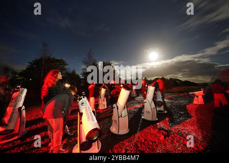 Un gruppo di stelle utilizza i telescopi per dare un'occhiata alla Cometa A3, nota anche come Tsuchinshan-Atlas, e alla luna piena nei cieli sopra la locanda Twice Brewed nel Northumberland International Dark Sky Park, nel nord-est dell'Inghilterra. Data foto: Giovedì 17 ottobre 2024. Foto Stock