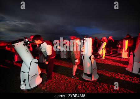 Un gruppo di stelle utilizza i telescopi per dare un'occhiata alla Cometa A3, nota anche come Tsuchinshan-Atlas, e alla luna piena nei cieli sopra la locanda Twice Brewed nel Northumberland International Dark Sky Park, nel nord-est dell'Inghilterra. Data foto: Giovedì 17 ottobre 2024. Foto Stock