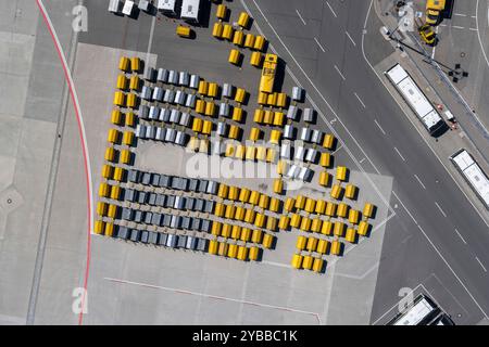 Vista dall'alto dei carrelli per bagagli gialli e neri vuoti sull'asfalto dell'aeroporto Foto Stock