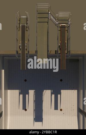Vista dall'alto delle piattaforme per immersioni che gettano ombre sulla piscina soleggiata e vuota Foto Stock