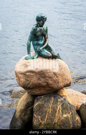 La Sirenetta è una statua in bronzo raffigurante il personaggio nella fiaba di Andersen, esposta su una roccia vicino al mare a Copenaghen, Danimarca. Foto Stock