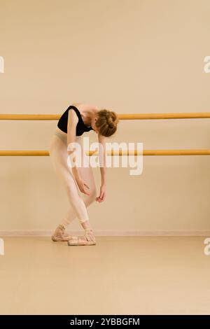 Ballerina di balletto inclinata in avanti con le braccia appese, con un leggero tratto. Foto Stock