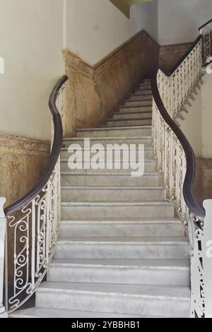 811 maestosa scalinata in marmo con ringhiera ondulata in ferro e corrimano in legno di un edificio in stile eclettico nella Habana Vieja-città Vecchia. L'Avana-Cuba. Foto Stock