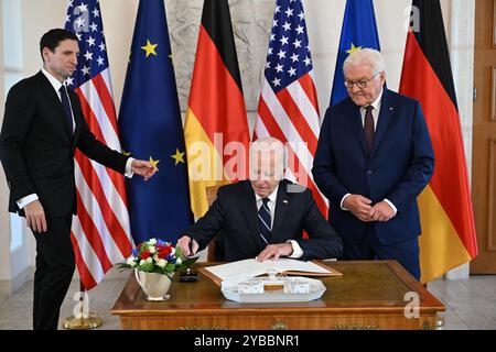 Berlino, Germania. 18 ottobre 2024. Il presidente DEGLI STATI UNITI Joe Biden (M) firma il libro degli ospiti accanto al presidente tedesco Frank-Walter Steinmeier (r) alla cerimonia di benvenuto al Palazzo Bellevue di Berlino, Germania. Credito: Soeren Stache/dpa/Alamy Live News Foto Stock