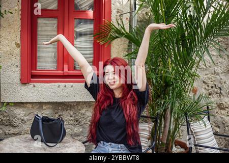 Ritratto di una bella giovane donna con lunghi capelli rossi seduti in un bar Foto Stock