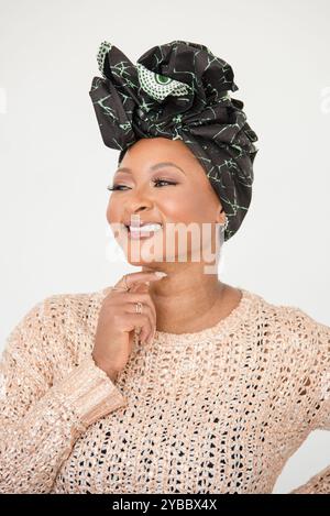 Donna afroamericana che indossa un copricapo sorridente Foto Stock