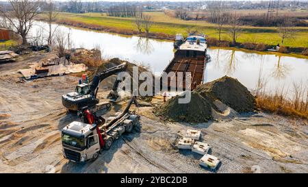 Sopra la vista dell'escavatore e del carro attrezzi, essi devono estrarre parte del letto, della chiatta, della costa fluviale, della cassazione, della nave di smantellamento, taglio r Foto Stock