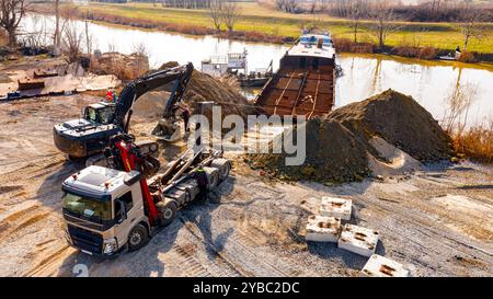 Sopra la vista dell'escavatore e del carro attrezzi, essi devono estrarre parte del letto, della chiatta, della costa fluviale, della cassazione, della nave di smantellamento, taglio r Foto Stock