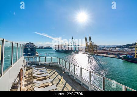 Barcellona. Espain - 28 settembre 2024: Una vista panoramica dal ponte di una nave da crociera attraccata al porto di Barcellona. Sullo sfondo, una nave cargo AN Foto Stock