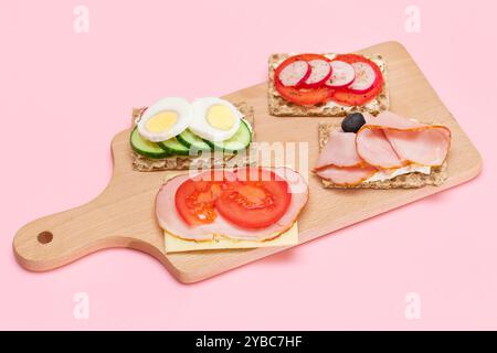 Diversi tipi di pane integrale con Prato, pomodoro, Rasth, cetriolo e formaggio. Colazione facile. Dieta alimentare. Panini veloci e sani. Croccante con gustoso ripieno. Snack dietetico sano Foto Stock