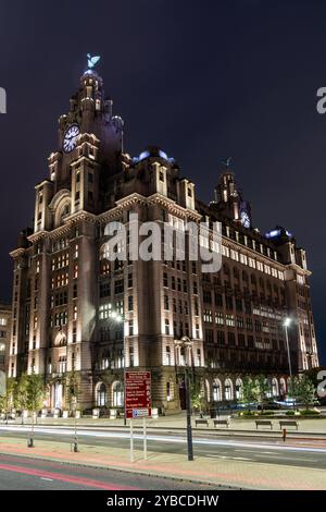 L'edificio reale del fegato si erge alto e illuminato di notte con le luci delle auto di passaggio che sfocano la strada sottostante Foto Stock