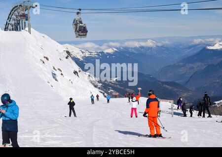 Meribel, Francia - 13 marzo 2024: Sciatori e snowboarder nella stazione sciistica di Meribel in Francia. Vista dalla cima del Mont Vallon che si affaccia sulle tre valli Foto Stock