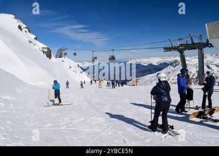 Meribel, Francia - 13 marzo 2024: Sciatori e snowboarder nella stazione sciistica di Meribel in Francia. Vista dalla cima del Mont Vallon che si affaccia sulle tre valli Foto Stock