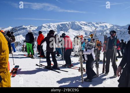 Meribel, Francia - 13 marzo 2024: Cima delle stazioni sciistiche Meribel e Courchevel, tre valli. Sciatori e snowboarder sulla cima del monte Saulire. Foto Stock