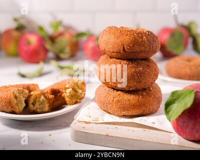 Pila di ciambelle al sidro di mele in un ambiente luminoso e luminoso con mele appena raccolte Foto Stock
