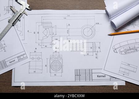 Disegni tecnici diversi, calibro a corsoio e matita su tavolo in legno, vista dall'alto Foto Stock