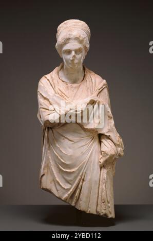 Ritratto Statua di una donna, circa d.C. 120-130. Ulteriori informazioni: Questa statua frammentaria raffigurante una donna avvolta in un mantello. Le sue caratteristiche facciali lisce e delicate suggeriscono una giovane donna, o almeno una donna scolpita in uno stile classico senza età. La sua acconciatura distintiva permette agli studiosi di datare questa statua al periodo compreso tra il 120 d.C. e il 130. Le donne di tutto l'Impero adottarono questo stile con i capelli tirati indietro dal viso e i lunghi capelli avvolti in trecce dietro la testa a imitazione delle donne della famiglia imperiale. La donna e' un po' Foto Stock