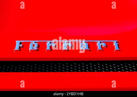 Primo piano del logo rosso del produttore cromato del coperchio del vano bagagli posteriore Ferrari. Foto Stock