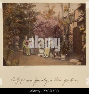 Una famiglia giapponese nel loro giardino, circa 1873-1883. Tre adulti e una ragazza seduti su rocce e una sedia circondati da alberi, cespugli fioriti e piante in vaso. Foto Stock