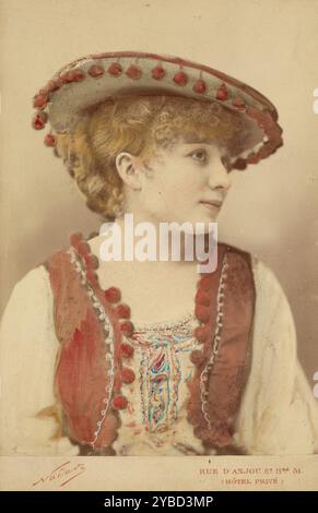 Marguerite Ugalde, 1883 anni. Ritratto dell'attrice e cantante d'opera Marguerite Ugalde in costume. Indossa un cappello con un bordo rifinito con pompami colorati a mano in rosso e un gilet coordinato decorato con gli stessi pompon che rifiniscono i bordi. Foto Stock