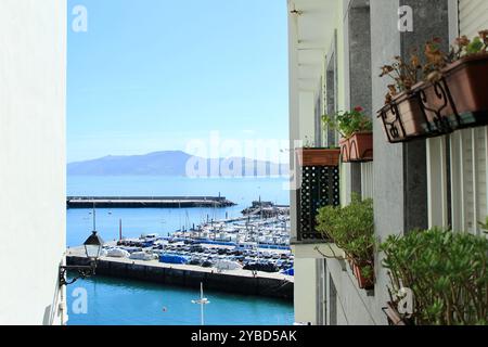 Vista panoramica dalla finestra aperta in una soleggiata giornata estiva del Mar Mediterraneo e della costa spagnola da una camera a Getaria, Spagna Foto Stock