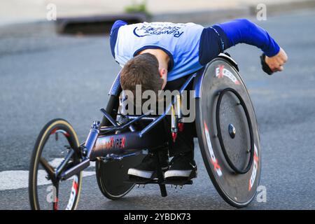 Babylon, New York, Stati Uniti d'America - 22 ottobre 2023: Un atleta determinato naviga su un percorso di strada su una sedia a rotelle da corsa, mostrando abilità e concentrazione. Foto Stock