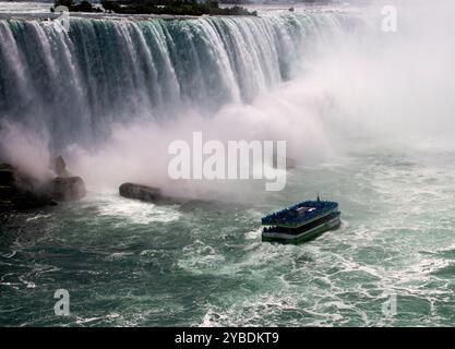 I visitatori fanno un tour in barca attraverso la nebbia vicino alle splendide cascate del Niagara. Foto Stock